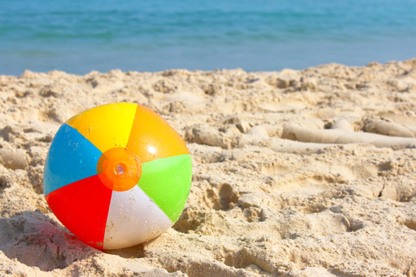 Ball on a beach with blue sky and water in background